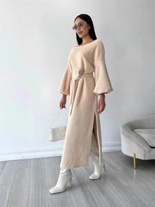 Elegant beige knit maxi dress with lantern sleeves, waist tie, and side slit detail