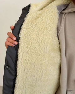 Close-up of charcoal gray hooded jacket with plush beige faux shearling lining and metal snaps
