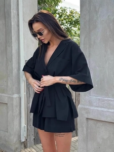 Women's chic black two-piece set featuring a belted V-neck top and matching loose shorts