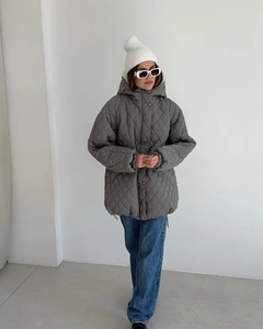 Detail view of a gray quilted hooded jacket with diamond pattern and button closure