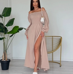 Detail of off-shoulder ruched dress with long sleeves and high slit in beige color