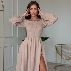 Detail of off-the-shoulder smocked bodice and lantern sleeves on beige maxi dress