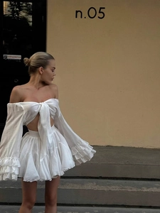 Two-piece white set featuring a V-neck tie-up crop top and layered ruffle mini skirt