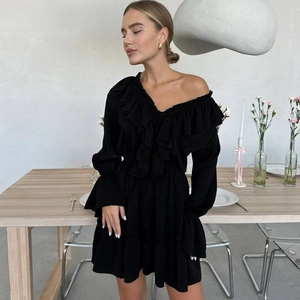 Detail of elegant black off-shoulder chiffon dress with ruffled layers and flared sleeves