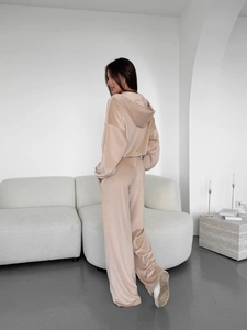 Détail de la texture et du drapé du velours sur cet ensemble beige pour femmes