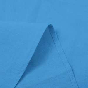 Close-up of bright blue short sleeve shirt fabric with neat stitching and plain weave texture