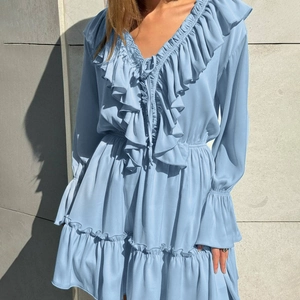 Detailed view of V-neck ruffles and layered chiffon fabric on light blue dress