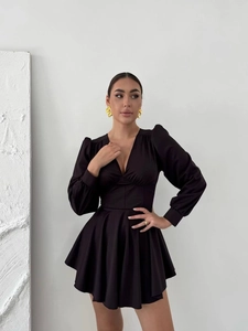 Elegant black V-neck mini dress with puff sleeves and flared skirt on a fashion model