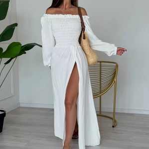 Detailed view of white off-the-shoulder dress with smocked bodice and high side slit