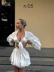 Elegant white two-piece set with V-neck tie-front top and tiered ruffled mini skirt