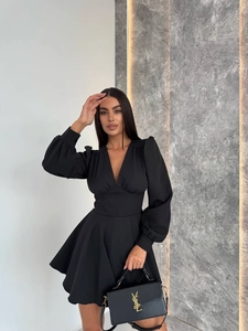 Detailed view of the elegant V-neckline and puff sleeve design on this black mini dress