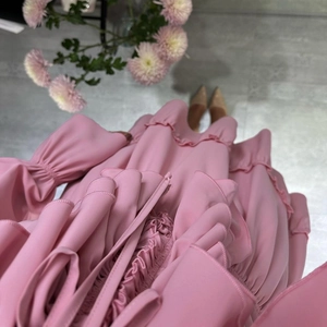 Detail view of pink chiffon dress featuring layered ruffles and elastic smocked sleeves