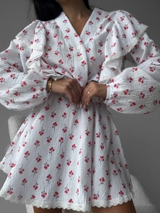 White cherry print V-neck dress with puff sleeves and lace trim detail on a model