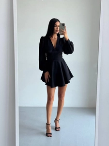 Detail of elegant black V-neck mini dress featuring puff sleeves and high waist design