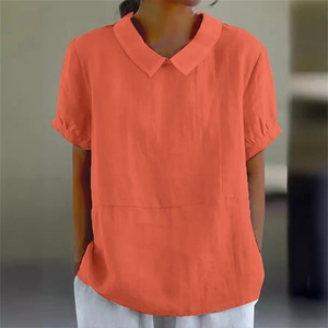 Detail of loose-fit orange short-sleeve shirt featuring a Peter Pan collar and soft linen fabric