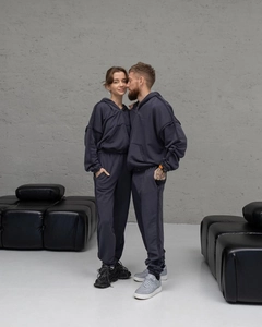 Détail d'un ensemble sweat à capuche gris zippé et pantalon de jogging à bandes latérales