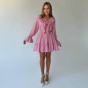 Detail view of pink chiffon dress with ruffled V-neck and flared sleeves texture