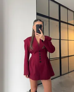 Detail showing the deep red blazer dress with V-neckline and button-up waist silhouette