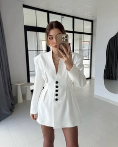 Detailed close-up of white blazer dress showing five decorative black buttons and slim waist