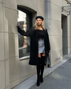 Detail of elegant black wool coat with V-neck collar and stylish waist belt with buckle