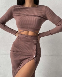 Detail of mauve ribbed knit set showing crop top waist ties and side button slit skirt