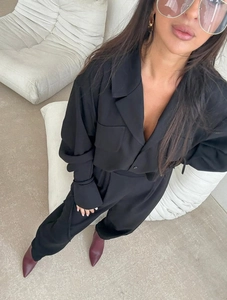 Détail d'une chemise noire en crêpe à manches longues avec col à revers et pantalon