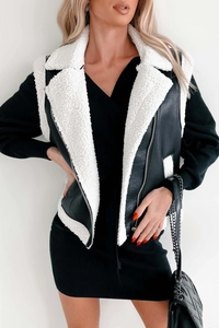Detail of faux leather shearling vest with white fleece trim and metal zipper closure