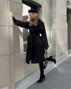 Detail of elegant black wool coat with tie waist belt and large side pockets