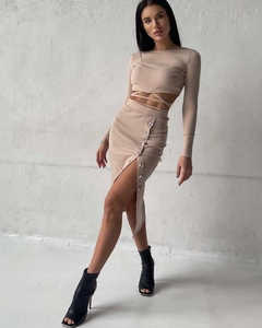 Detail of the cropped knit top with cross tie design and high slit buttoned skirt