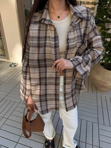 Detail of classic brown plaid shirt fabric texture and resin button closure