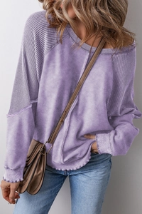Detail of lavender sweatshirt showing waffle knit texture on sleeves and washed fabric body
