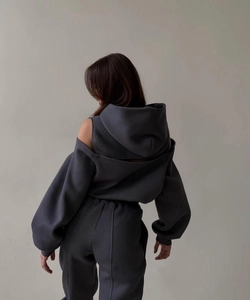 Détail d'un sweat à capuche gris foncé épaules dénudées et pantalon à cordon assorti