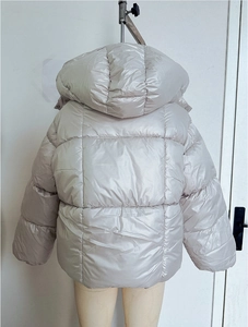 Détail du dos d'une doudoune matelassée en tissu métallisé champagne avec capuche