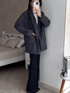 Detail view of deep grey oversized wool blazer featuring large heart-shaped pockets for women