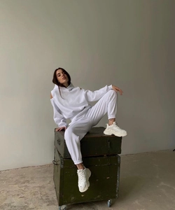 Détail d'un ensemble jogging blanc à épaules dénudées avec des baskets compensées