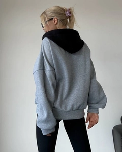 Rückansicht eines lässigen Oversize-Hoodies in Grau mit schwarzer Kapuze und Kontrastfarben