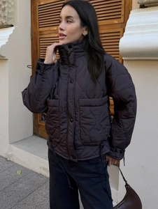 Detailed view of quilted texture and large pockets on a dark winter jacket