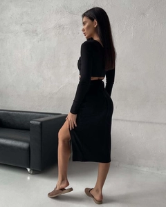 Detail of black long sleeve crop top and side slit midi skirt set in ribbed knit fabric