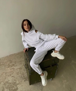 Détail d'un ensemble de survêtement blanc avec épaules dénudées et pantalon de jogging assorti