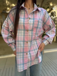Detail of the pink and blue plaid shirt featuring a chest pocket and wood buttons