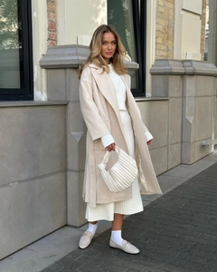 Close-up of elegant beige wool coat with large lapels and waist belt detail