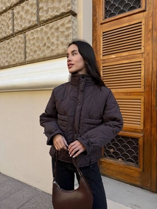 Detail of dark brown quilted jacket featuring onion quilting and adjustable drawstring cuffs