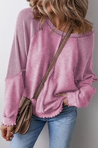 Detail showing the textured waffle knit raglan sleeve and stitching on pink t-shirt