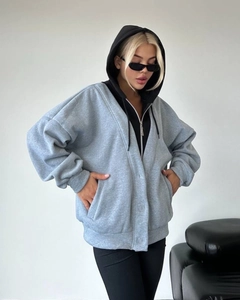 Detail eines grauen Oversize-Zipp-Hoodies mit schwarzer Kapuze und überschnittenen Schultern