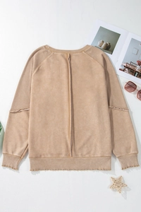 Detail of khaki sweatshirt featuring vertical back seam and waffle textured patchwork sleeves