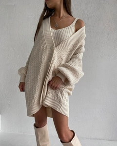 Detailed macro view of cream-white chunky knit texture and large buttons on the cardigan
