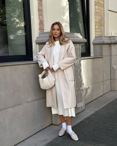 Detail of oatmeal wool coat featuring an elegant lapel and belted waist for women