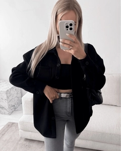 Detail view of thickened black lapel wool coat with stylish metal buckle belt and quilted bag