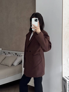 Close-up of a women's dark brown wool blazer featuring a unique heart-shaped pocket detail