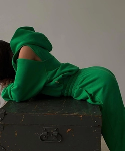 Détail d'un ensemble de loisirs vert vif avec sweat à capuche ajouré et pantalon de sport